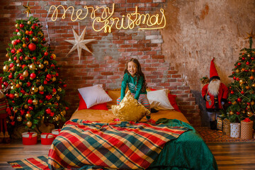 little girl Asian girl in her pajamas in the bedroom messing around on the cushions, Christmas, new...