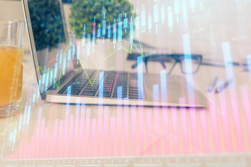 Stock market graph on background with desk and personal computer. Double exposure. Concept of financial analysis.