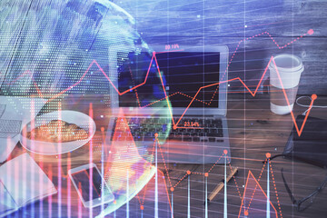 Double exposure of graph and financial info and work space with computer background. Concept of international online trading.