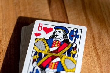 Paper playing cards for playing poker on the background of a wooden brown board.