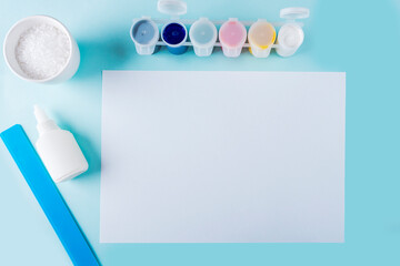 Concept of DIY and kid's creativity. Step by step instruction: how to make snowflake from glue and salt. Step1 preparation tools (glue, salt, paint, sheet of paper) for children Christmas craft