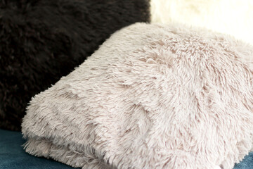 Colorful fluffy pillows, house decoration, white black grey cushions on sofa, fur textile  