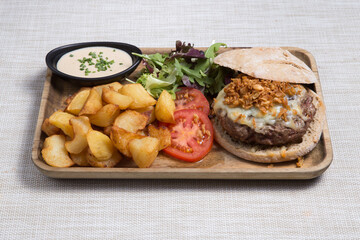 Burger with sliced Roast beef and potato wedges.
