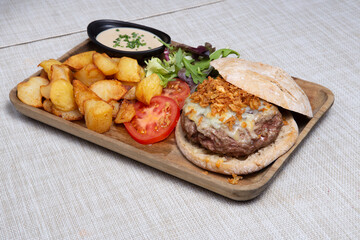 Burger with sliced Roast beef and potato wedges.
