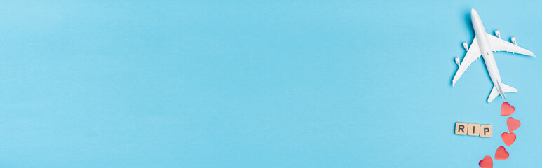 top view of plane model, word rip and red hearts on blue , banner