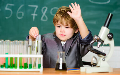 Kid study biology and chemistry in school. School education. Explore biological molecules. Toddler genius baby. Boy near microscope and test tubes in school classroom. Technology and science concept