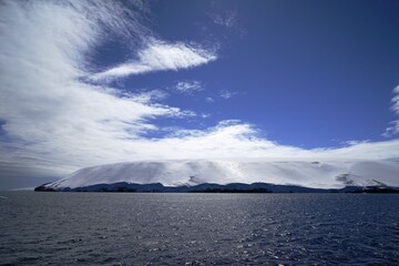 White icebergs and white clouds form an arc shape.