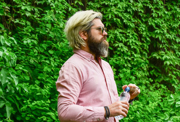 Thirsty guy drinking bottled water. Healthy lifestyle. Summer heat. Drinking clear water. Safety and health. Water balance. Man bearded tourist drinking water plastic bottle nature background