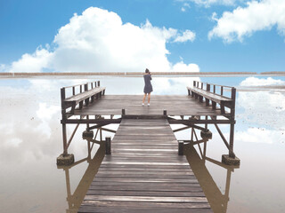 rear view of young asian woman use digital camera taking photo of view of lake with beautiful blue sky.