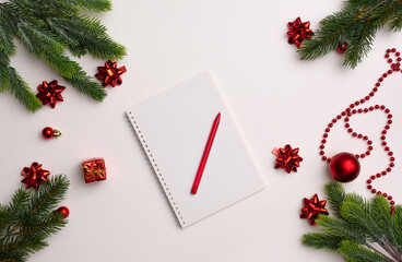 Christmas composition. Notepad with goals for 2021. Notepad, pen, gift boxes, letter envelopes, balls and stars. Concept business Christmas. Goals and objectives