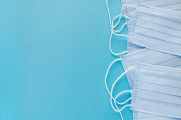 Medical masks on a blue background, top view, copy space. Surgical medical mask isolated on blue...