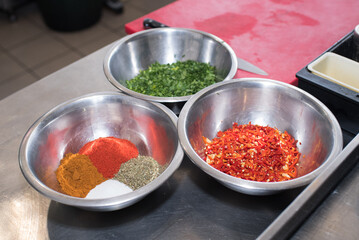 Bowls with dill, parsley, spices, salt, etc. for filling minced meat