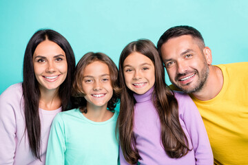 Photo portrait of full family hugging isolated on vivid turquoise colored background