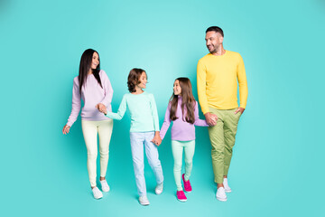 Fototapeta premium Photo portrait of big family with little children going on a walk holding hands isolated on vivid turquoise colored background