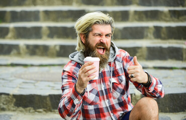 Fototapeta premium Pure pleasure. Hipster relax on stairs. Having rest. Caffeine dose. Good mood. Bearded man drink coffee urban background. Take away coffee. Third wave coffee culture. Man with beard drinking coffee
