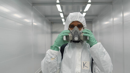 African medical worker in overall putting on respiratory mask working in hospital