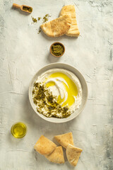 Popular middle eastern appetizer labneh or labaneh, soft white goat milk cheese with olive oil,...