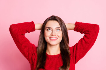 Obraz na płótnie Canvas Photo of young lovely lady arms behind head look up empty space wear red sweater isolated pink color background