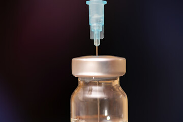 Close-up of a syringe in a vial with a vaccine.