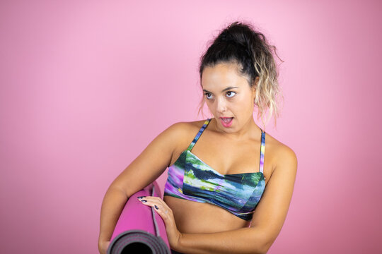 Young beautiful woman wearing sportswear and holding a splinter over isolated pink background afraid and shocked with surprise expression, fear and excited face.