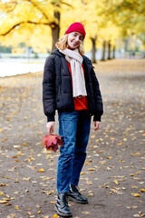 Junge Frau im Herbst im Park mit Blatt, Herbstblatt, Laub, 