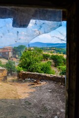 BULGARIA, KARDZHALI, 19.08.2011. Landscape and village view from old and wooden window and broken glass.