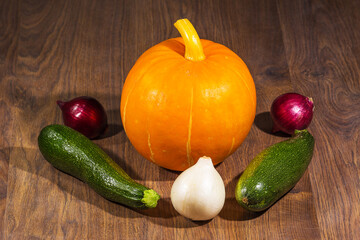 autumn harvest pumpkin, zucchini, red onion, white onion on the table