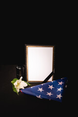 lily, mirror, ashes and american flag on black , funeral concept