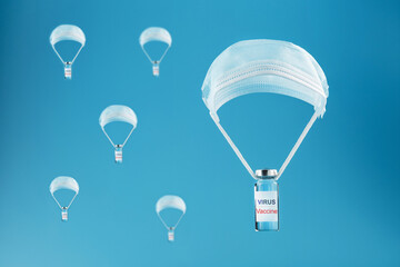 Ampoules with a vaccine against coronavirus infection and viruses dropped by parachute from a protective mask on a blue background.
