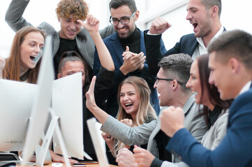 happy business team cheering near the desktop.