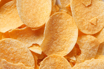 Bowl with tasty potato chips on wooden background .