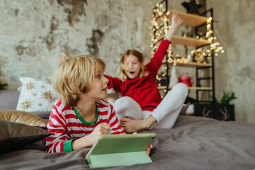 Boy and girl using tablets in Christmas time