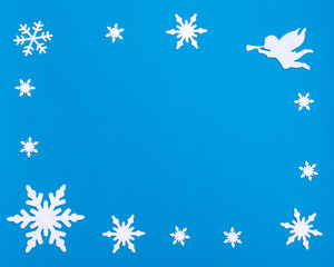 flat lay composition with white blank notepad, blue bell, white angel playing the trumpet and Christmas snowflakes