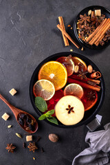 Mulled wine traditional christmas hot drink with citrus, apple and spices in pan. Top view.on black background. Recipe.