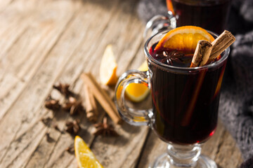 Traditional mulled wine with spices on rustic wooden table.Copy space