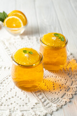 Sweet dessert jelly pudding with orange citrus in glass jar on white background