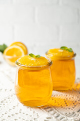 Sweet dessert jelly pudding with orange citrus in glass jar on white background