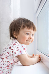 child toddler looking out of the window - 395747444