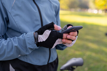 close-up of a cyclist's hand he is typing a message on the phone.