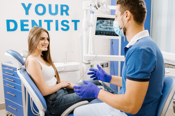 Fototapeta premium Man dentist having discussion with woman patient