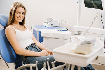 Young pretty woman in dentist chair waiting for treatment