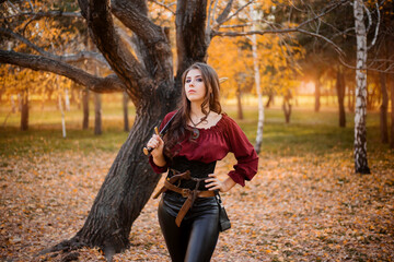 Portrait of an attractive slender woman with a saber on her shoulder against the background of an...