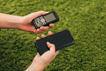 The Human Hand Picks an Old Phone That Lies Near New Smartphones