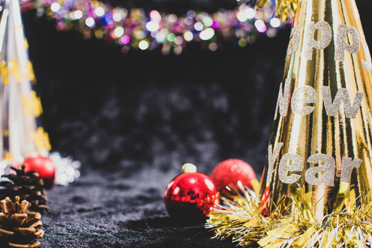 Happy new year celebration concept decorated with hat,balls,dried pine cones and black background with copy space - Powered by Adobe