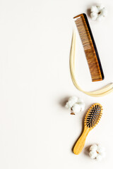 Strand of blond hair wirh hairbrush, flat lay