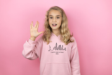 Young beautiful child girl standing over isolated pink background doing star trek freak symbol