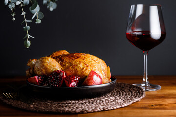 Whole roast chicken with pomegranate, apple and red wine on a festive table. Christmas or New Year...