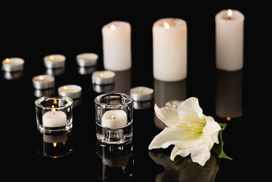 lily, candles on black background, funeral concept, stock image