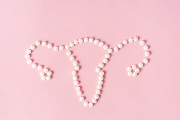 The uterus is laid out of tablets on a pink background. Space for text