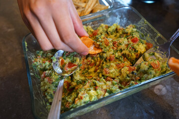 hand taking guacamole